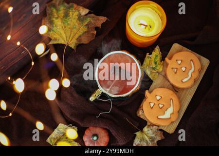 Eine Tasse Tee und auf einem Holztisch mit Herbstblättern und Kürbis Stockfoto