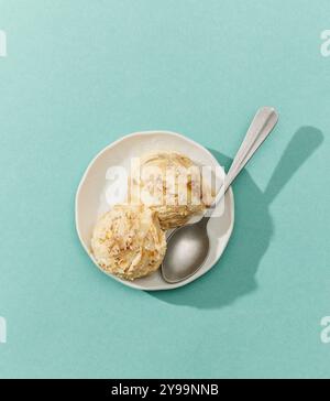 Schüssel Karamell-Eis isoliert auf blauem Hintergrund, Draufsicht Stockfoto