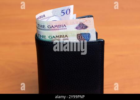 Gambische Geld - Dalasi in der schwarzen Brieftasche Stockfoto