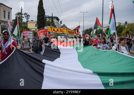 Athen, Griechenland. Oktober 2024. Demonstranten halten eine riesige palästinensische Flagge und schreien Slogans. Hunderte Demonstranten marschierten am 5. Oktober 2024 in Griechenland gegen Kriege und in Solidarität mit dem Libanon und Palästina in den Straßen Athen. (Foto: Dimitris Aspiotis/Pacific Press/SIPA USA) Credit: SIPA USA/Alamy Live News Stockfoto