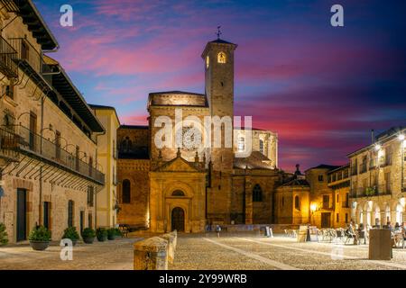 Blick auf die Seitenfassade der Kathedrale von Sigüenza, Guadalajara, Castilla-la Mancha, Spanien, von der Plaza Mayor aus gesehen, mit künstlichem Licht in der Abenddämmerung Stockfoto