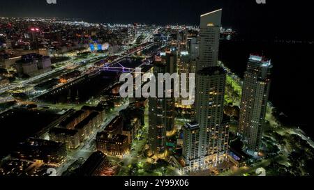 Stadtlandschaft von Puerto Madero bei Sonnenuntergang, mit der Stadt Buenos Aires im Hintergrund. Nachtsicht aus der Vogelperspektive. Stockfoto