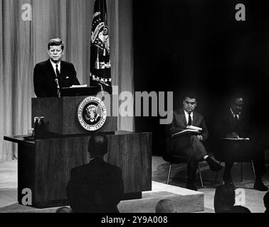 US-Präsident John F. Kennedy beim Rednerpult während der Pressekonferenz, Pressesprecher Pierre Salinger und Associate Press Secretary Andrew Hatcher sitzen rechts auf der Bühne, Auditorium des US-Außenministeriums, Washington, D.C., USA, Abbie Rowe, Fotos Des Weißen Hauses, 11. Oktober 1961 Stockfoto