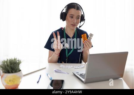 Glückliche schöne junge Ärztin in Kopfhörern, die mit dem Patienten auf Videoanruf sprechen, Laptop für Online-Konferenz-Chat verwenden, professionellen Konsul geben Stockfoto