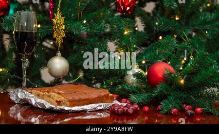 Nahaufnahme Der Weihnachtsdekoration Mit Weihnachtskuchen, Wein Und Baum Stockfoto