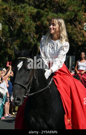 Badacsony, Balaton, Ungarn - 8. September 2024: Straßenparade des Weinerntefestes, junge Frau in traditioneller Tracht reitet auf einem Pferd Stockfoto