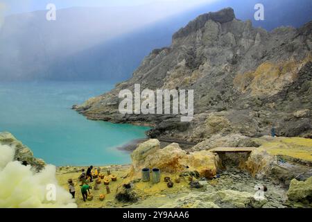 Schwefelbergleute im ijen-Krater. Der Bergkrater auf einer Höhe von 23443 mdpl ist noch heute aktiv und hat das Potenzial, Lava auszugießen. Stockfoto