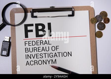Papierbogen mit Abkürzung FBI, Notizbuch und Zubehör von Agent auf Holzhintergrund Stockfoto