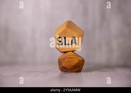 Text-SLA auf Holzwürfeln auf Bürotisch mit Kopierraum, die das Konzept des Service Level Agreements darstellen Stockfoto