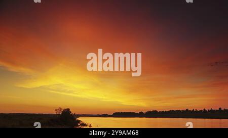 Wunderschöne Landschaft mit farbenfrohem Sonnenuntergang über dem Hintergrund des Flusses Stockfoto