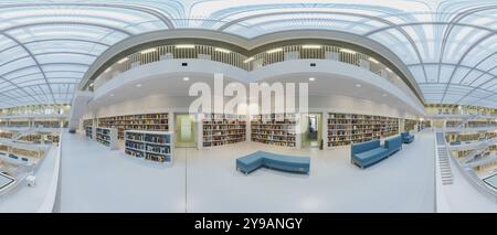 Moderne Bibliothek mit Glasdach und weißer Treppe, umgeben von Bücherregalen in einem hellen offenen Raum, öffentliche Bibliothek am Mailaender Platz, leer, Panorama Stockfoto