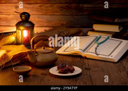 Viele Dattelpalmen stehen auf Schüsseln, Tellern, einer Tasse Wasser und Quran, eine Lampe im Islami-Stil auf den Holztischen, um auf die Zeit von Iftar zu warten, mit dem Co. Stockfoto