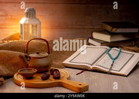 Viele Dattelpalmen stehen auf Schüsseln, Tellern, einer Tasse Wasser und Quran, eine Lampe im Islami-Stil auf den Holztischen, um auf die Zeit von Iftar zu warten, mit dem Co. Stockfoto