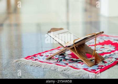 Islamisches Konzept - der heilige Al Quran mit geschriebener arabischer Kalligraphie Bedeutung von Al Quran und Rosenkranzperlen oder Tasbih, arabische Wortübersetzung: Der Heilige Stockfoto