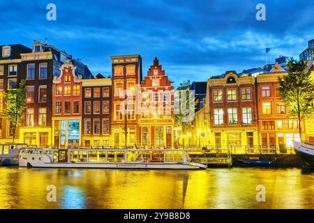 AMSTERDAM, Niederlande - 16. September 2015: berühmte Amstel Fluss und Nacht Blick der schönen Stadt Amsterdam. Boote, Autos auf der Straße. Niederlande Stockfoto