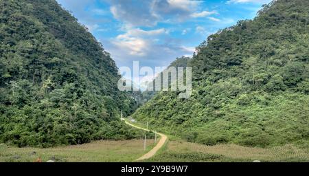 Ein riesiges Tal in Dong Van, Provinz Ha Giang, Vietnam, umgeben von majestätischen Kalksteinbergen. Die steilen, hoch aufragenden Klippen schaffen eine wilde und majestätische Atmosphäre Stockfoto