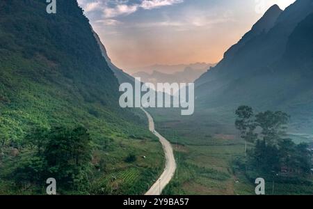 Ein riesiges Tal in Dong Van, Provinz Ha Giang, Vietnam, umgeben von majestätischen Kalksteinbergen. Die steilen, hoch aufragenden Klippen schaffen eine wilde und majestätische Atmosphäre Stockfoto