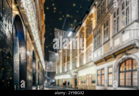 Verwischte Stadt mit weihnachtslichtern bei Nacht. Neujahrs-Bokeh-Hintergrund. Urbane Nachtszene mit defokussierten Stadtlichtern, Gebäuden und Menschen. Design. Co Stockfoto