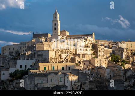 In der bezaubernden Stadt Matera, Apulien Italien, erheben sich alte Steinbauten steil gegen einen pulsierenden Himmel und enthüllen eine reiche Geschichte. Stockfoto
