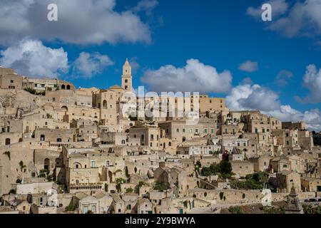 Eingebettet im Herzen Apuliens, bietet Matera bezaubernde Steinhäuser und eine historische Landschaft unter einem strahlend blauen Himmel, die Besucher einlädt, durch das reiche kulturelle Erbe zu schlendern. Stockfoto