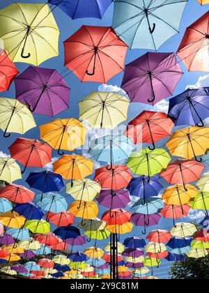 Installation von schönen bunten offenen Regenschirmen in Linien gegen blauen Himmel auf der Arcadia Gasse an einem sonnigen Tag in Odessa, Ukraine Stockfoto