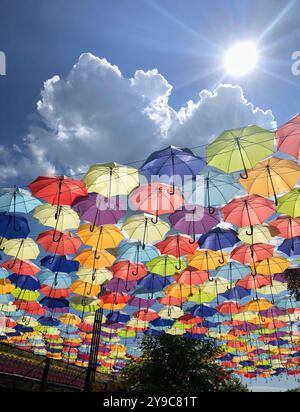 Installation von schönen bunten offenen Regenschirmen in Linien gegen blauen Himmel auf der Arcadia Gasse an einem sonnigen Tag in Odessa, Ukraine Stockfoto