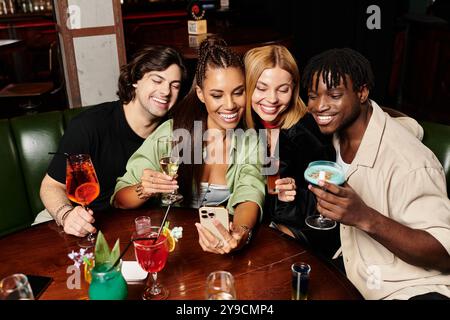 Eine Gruppe verschiedener junger Kollegen teilt Lächeln und Drinks, während sie einen lustigen Moment zusammen festhalten. Stockfoto