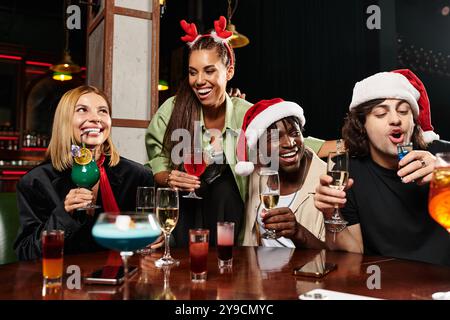 Eine Gruppe junger Kollegen feiert gemeinsam die Feiertage, lacht und trinkt. Stockfoto