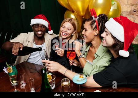 Eine Gruppe junger Kollegen feiert feierlich, lacht und trinkt gemeinsam. Stockfoto