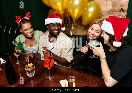 Ein lebhaftes Treffen verschiedener Kollegen, die während einer festlichen Feier Getränke und Lachen genießen. Stockfoto