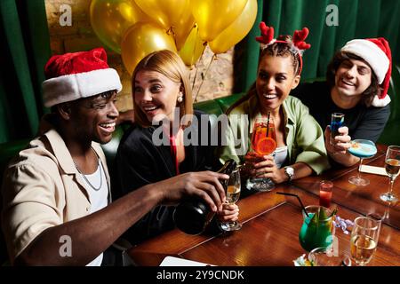 Die Kollegen nehmen fröhlich an festlichen Feierlichkeiten Teil und teilen gemeinsam Lachen und Getränke. Stockfoto