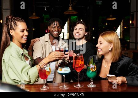 Kollegen stoßen mit bunten Cocktails an und genießen eine unterhaltsame und fröhliche Firmenfeier-Atmosphäre. Stockfoto