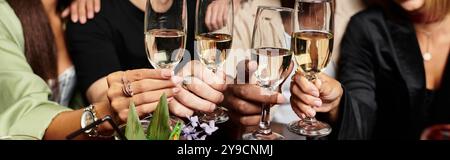 Begeisterte Kollegen stoßen mit einer Brille an und feiern den Erfolg bei einem lebhaften Treffen. Stockfoto