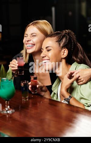 Zwei junge Kollegen lachen und trinken bei einem feierlichen Treffen. Stockfoto