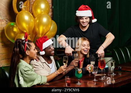 Junge Kollegen genießen Drinks und Lachen, während sie ihren Erfolg auf einer Firmenfeier feiern. Stockfoto