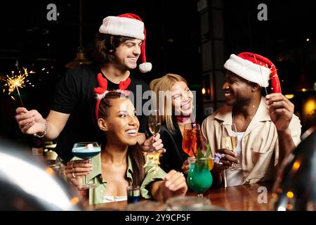 Junge Profis treffen sich fröhlich und feiern den Feiertagsgeist mit Drinks und Lachen. Stockfoto