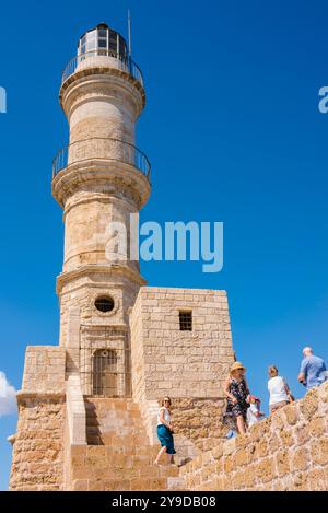 Leuchtturm von Hania, Blick auf die Menschen, die auf der Ufermauer des Leuchtturms laufen, die den historischen inneren Hafen in Chania (Hania), Kreta, Griechenland, umgibt Stockfoto