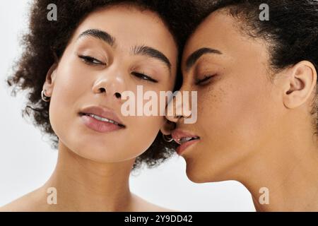 Die Aufnahme von zwei Frauen, die sich nahe neigen, mit Zärtlichkeit und künstlerischem Ausdruck der Freundschaft. Stockfoto