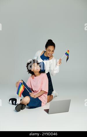 Eine lebhafte Feier der Freundschaft, während zwei Personen einen Moment der Freude mit Stolz-Flaggen teilen. Stockfoto