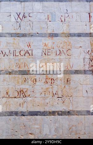 Die lateinischen Schriften an der Fassade der Chiesa di San Michele in Borgo, Pisa, Italien, sind Überreste aus dem 16. Jahrhundert. Stockfoto