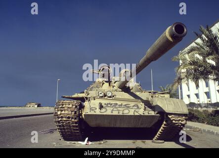 Erster Golfkrieg: 8. März 1991 ein verlassener irakischer Typ 69 Panzer neben dem Gebäude der Nationalversammlung Kuwaits an der Arabian Gulf Street in Kuwait City. Stockfoto