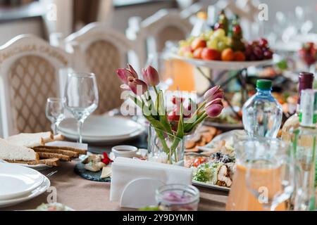 Elegantes Ambiente mit frischen Blumen und köstlicher Küche bei einem Bankett. Stockfoto