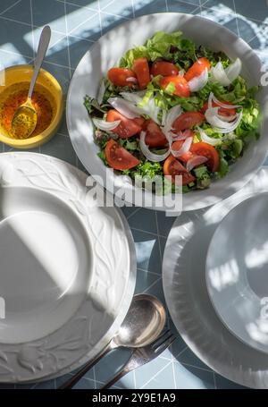 Teller und Schüssel Salat auf einem Tisch Stockfoto