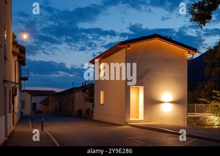 Neu renoviertes Haus, mit moderner Einrichtung, Nachtszene. Neben dem Haus befindet sich die Hauptstraße des kleinen Dorfes in der Schweiz. Niemand drinnen Stockfoto