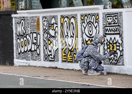 Der Straßenkünstler Mr. Doodle arbeitet an einem neuen Wandgemälde „Have A Doodley Day“ auf der Regents Park Rd Bridge Primrose Hill London Stockfoto