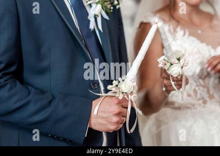Elegante Hochzeitskerzenzeremonie mit romantischen Details und wunderschöner Kleidung. Stockfoto