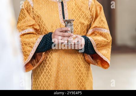 Goldene Gewänder und heiliger Chalice in einer ruhigen spirituellen Umgebung. Stockfoto