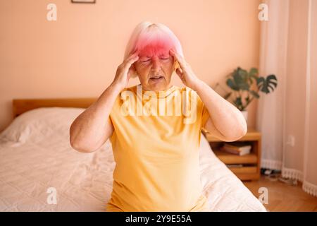 Eine gestresste, frustrierte Dame mittleren Alters, die an Kopfschmerzen leidet, sitzt auf einem Bett. Müde, kranke, reife Frau fühlt sich unwohl, berührt Stockfoto