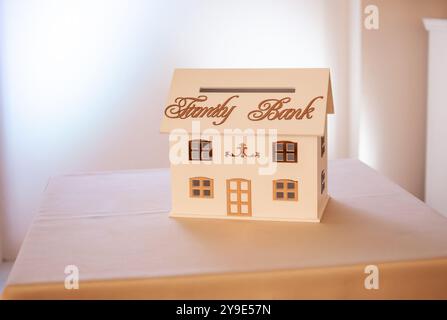 Charmantes Miniatur-Bankhaus mit elegantem Design und dekorativen Details. Stockfoto