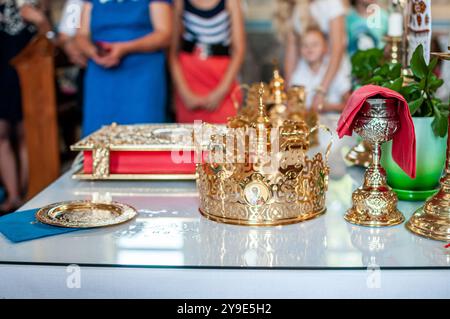 Goldene Krone und religiöse Artefakte auf dem Tisch elegant ausgestellt Stockfoto